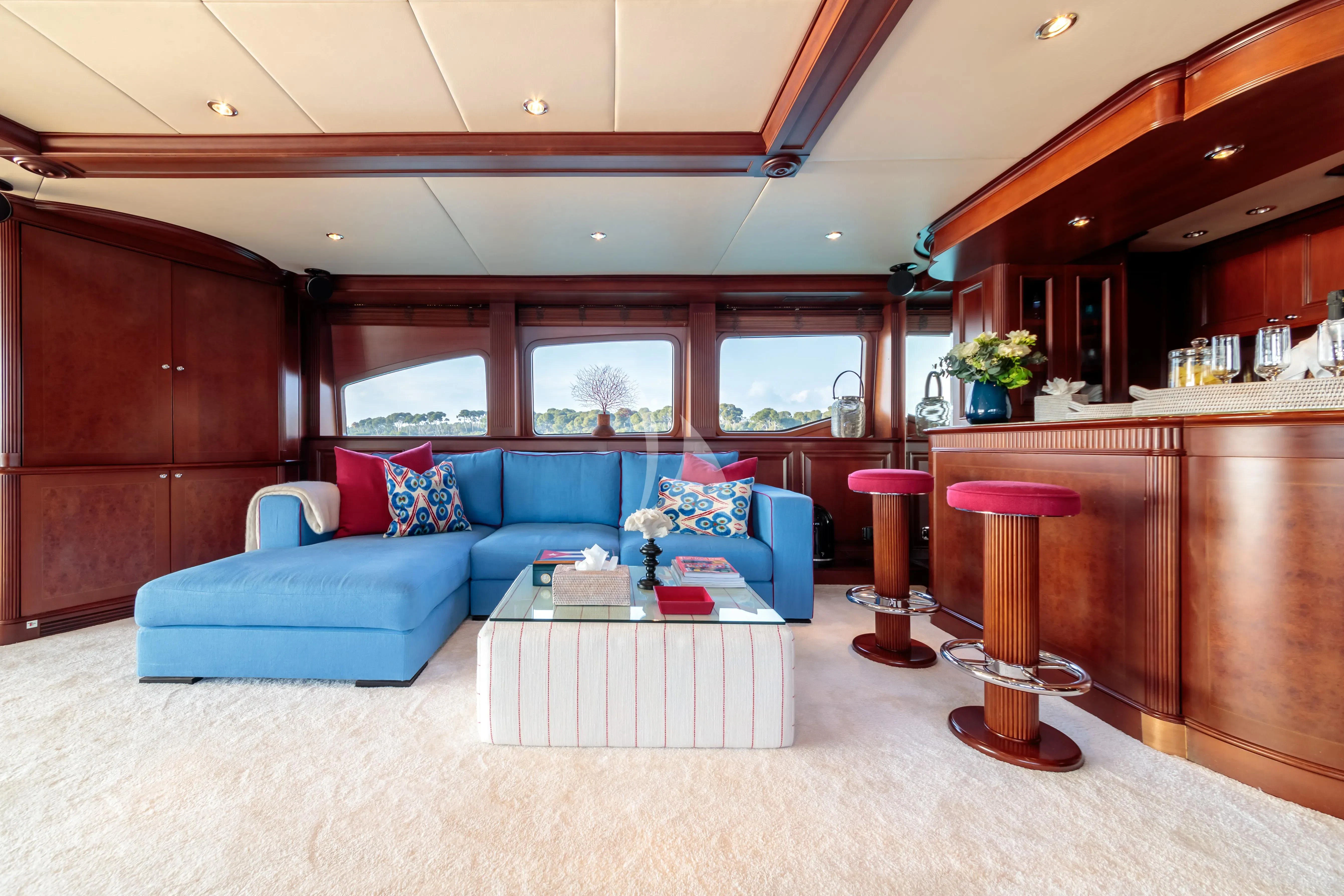 a living room with a blue couch aboard BANG! Yacht for Charter