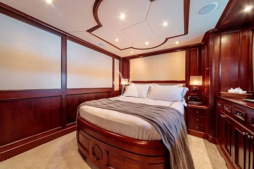 a bedroom with a bed and a mirror aboard BANG! Yacht for Charter