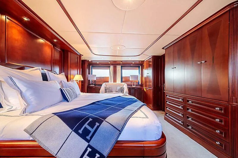 a bedroom with a bed and a chair aboard BANG! Yacht for Charter