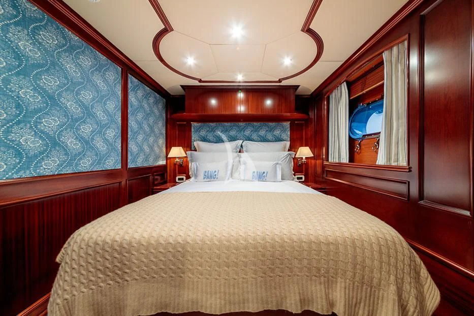 a bed with a large mirror above it aboard BANG! Yacht for Charter