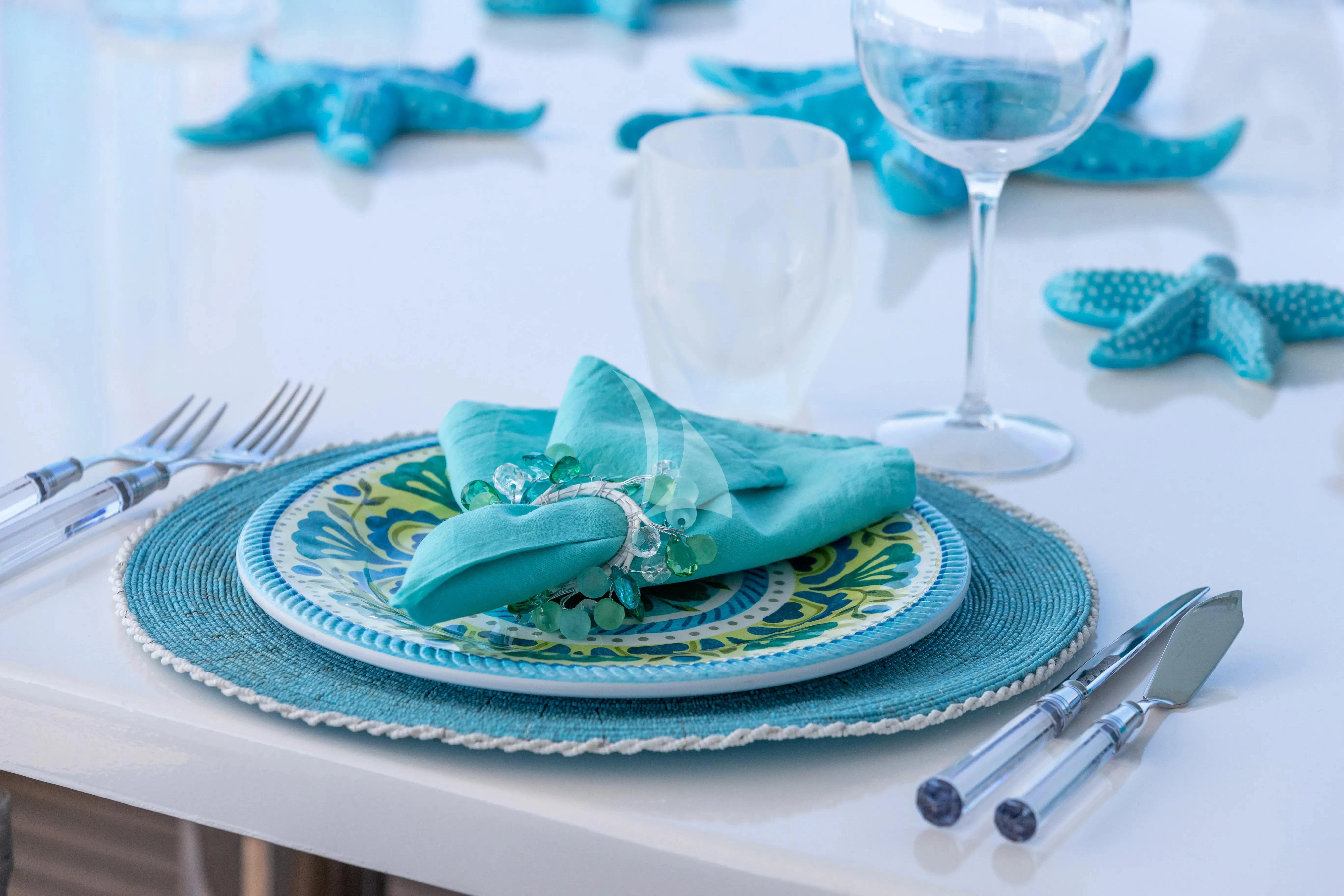 a plate with a glass and a plate with a napkin and a napkin aboard BANG! Yacht for Charter