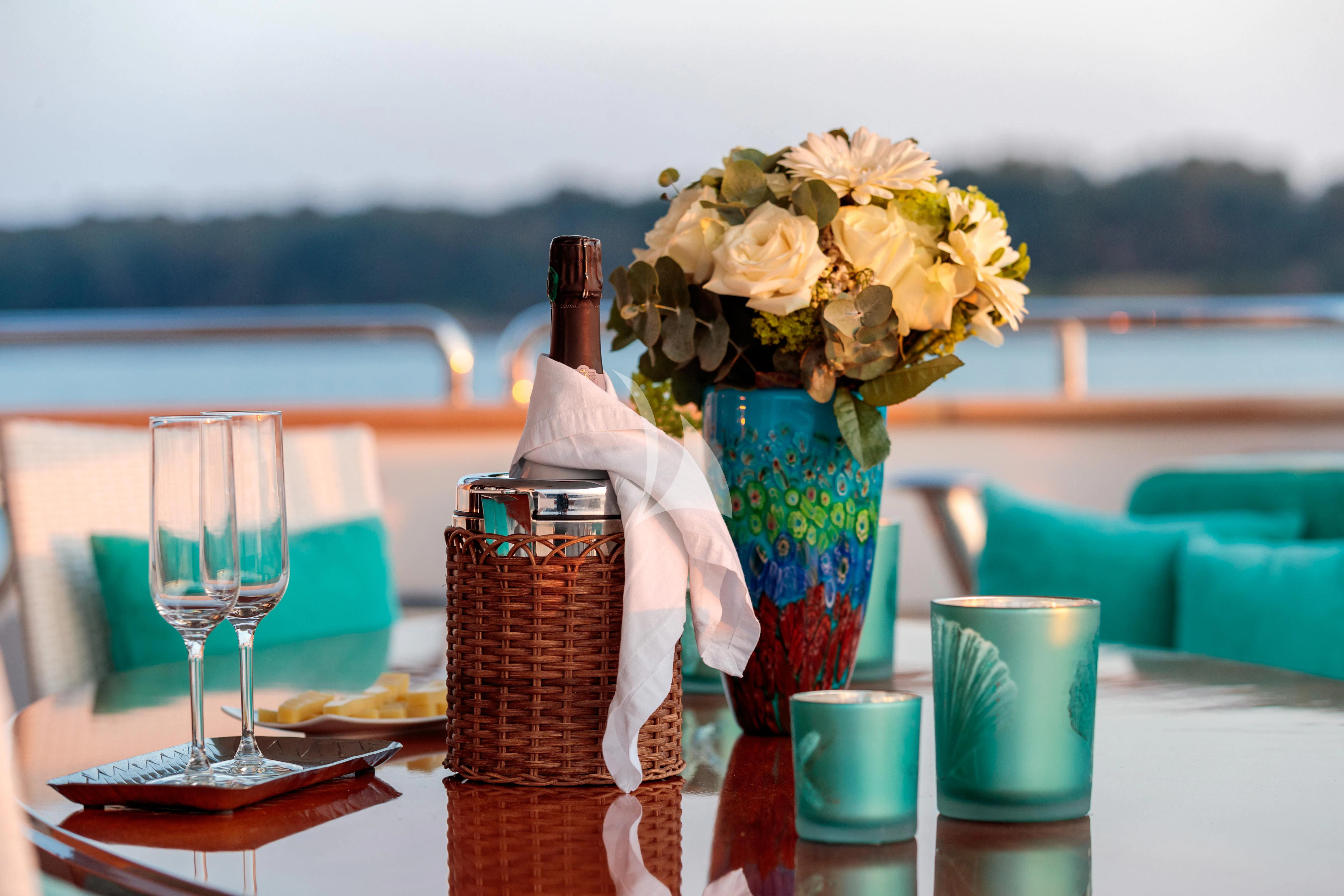a table with flowers and a bottle aboard BANG! Yacht for Charter