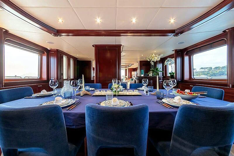 a dining room with a table set for a dinner aboard BANG! Yacht for Charter