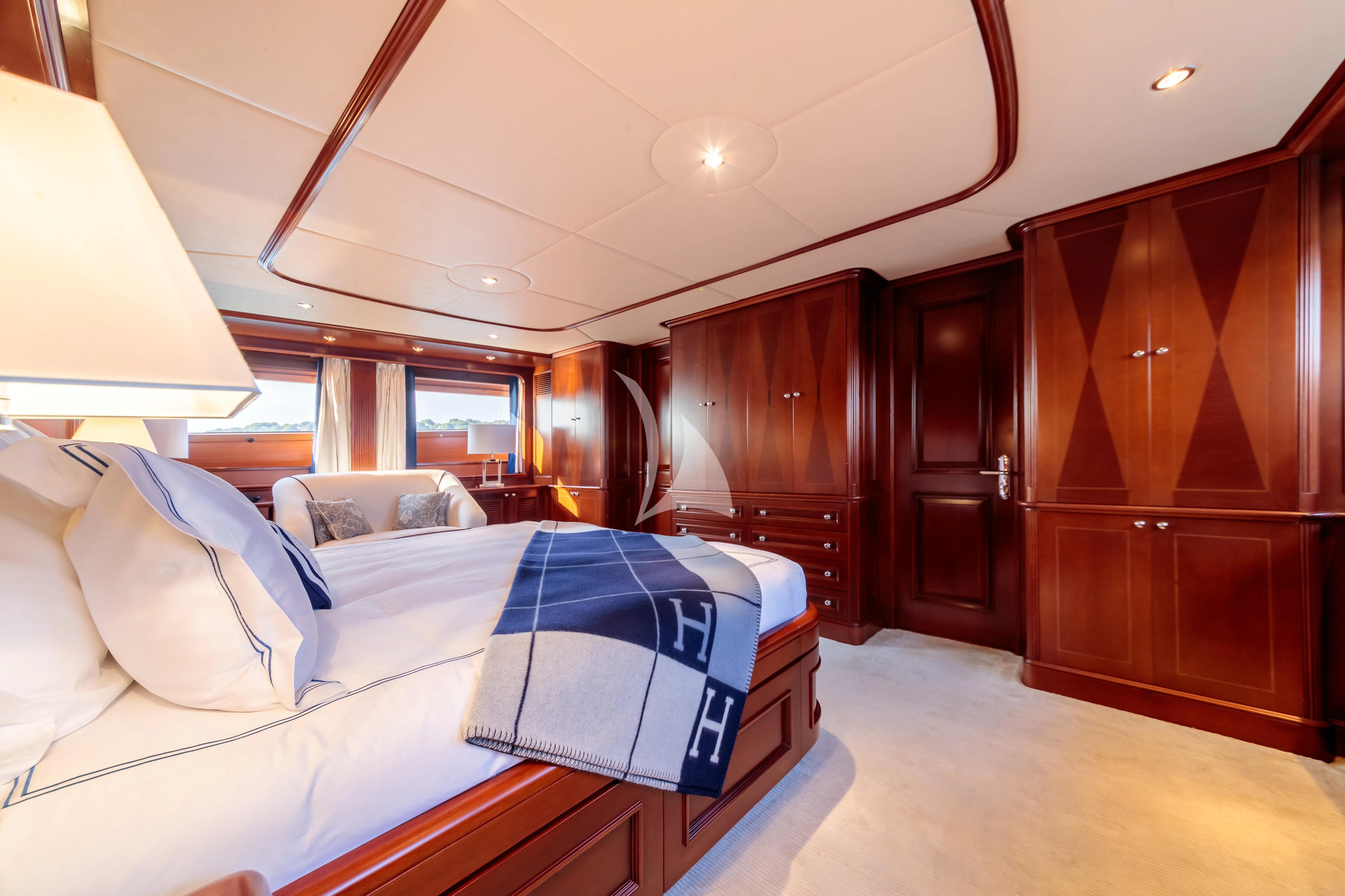 a bedroom with a bed and a wood cabinet aboard BANG! Yacht for Charter