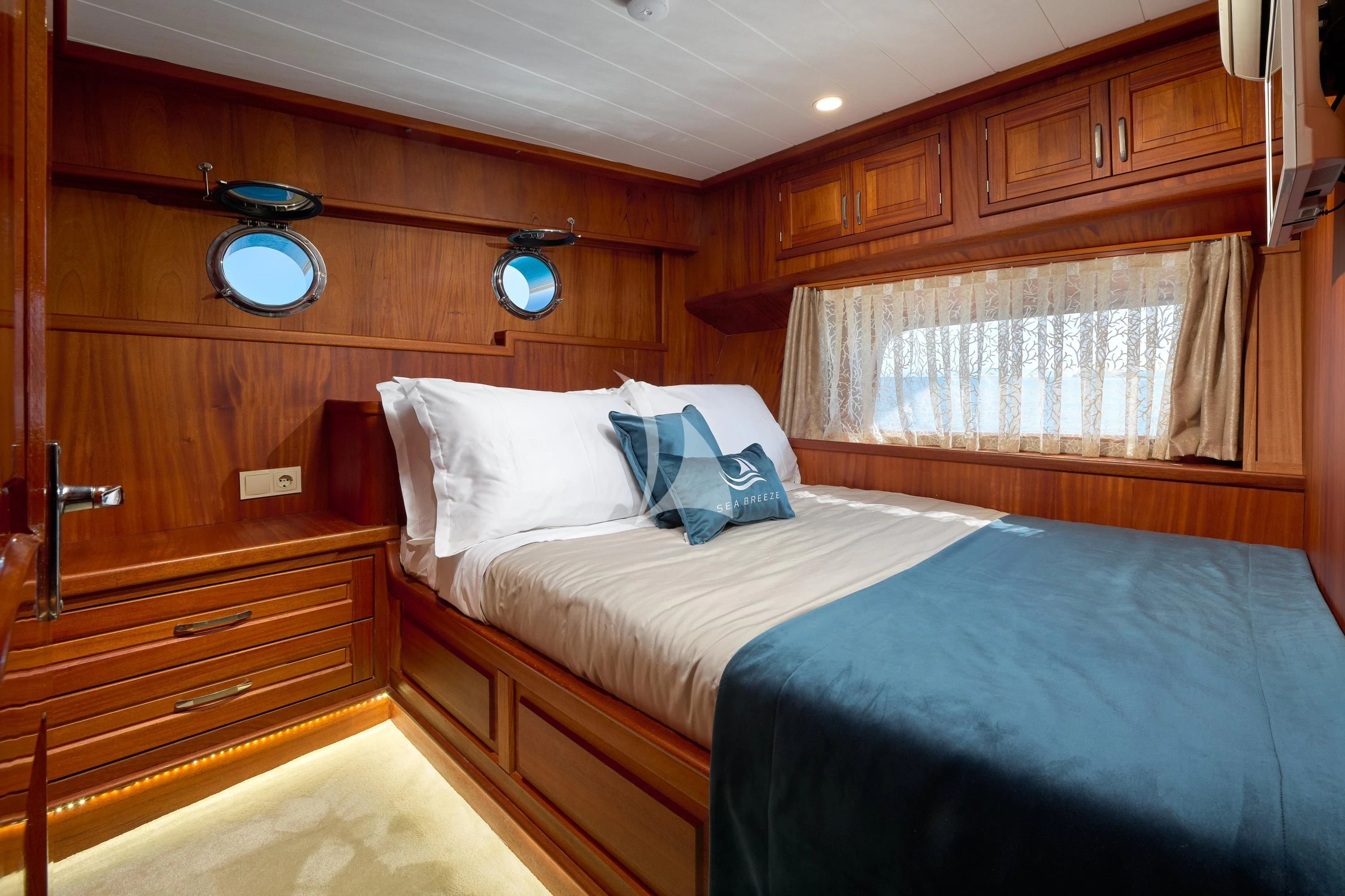 a bedroom with wooden furniture aboard SEA BREEZE Yacht for Charter