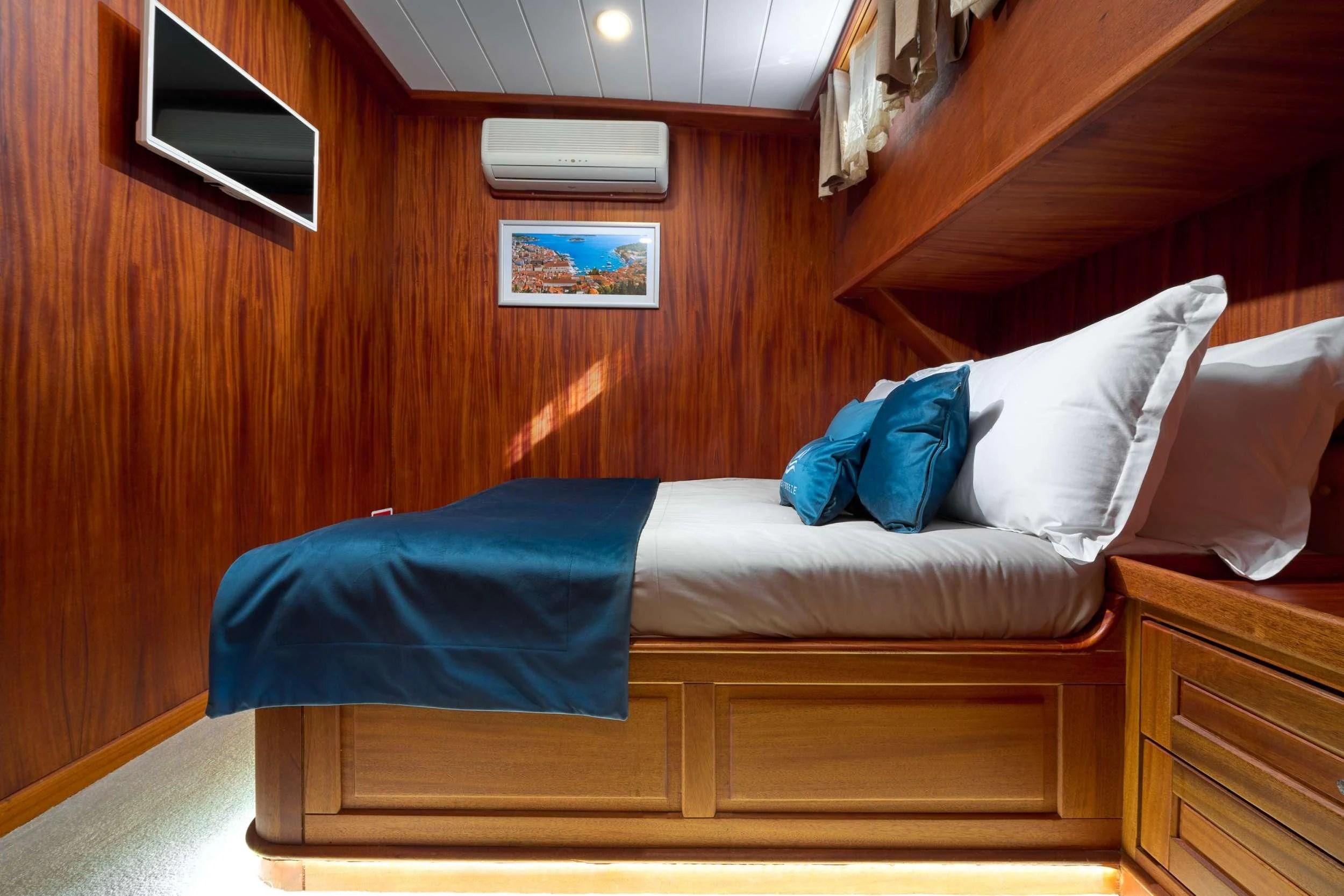 a bed with a blue pillow aboard SEA BREEZE Yacht for Charter