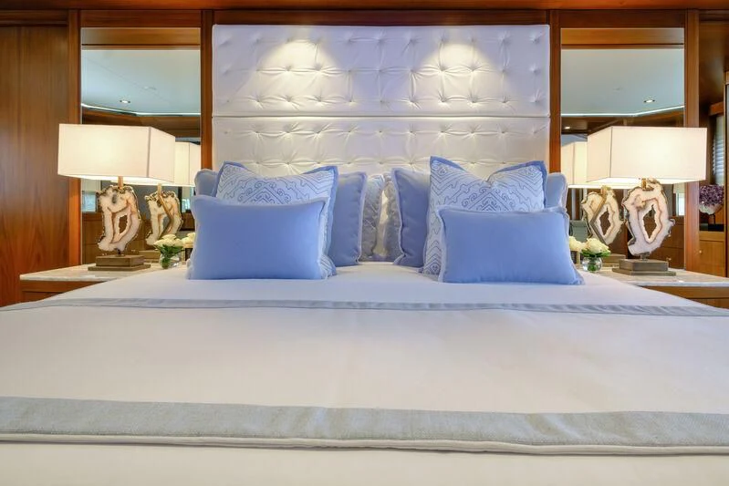a bed with blue and white pillows aboard MAISON BLANCHE Yacht for Charter