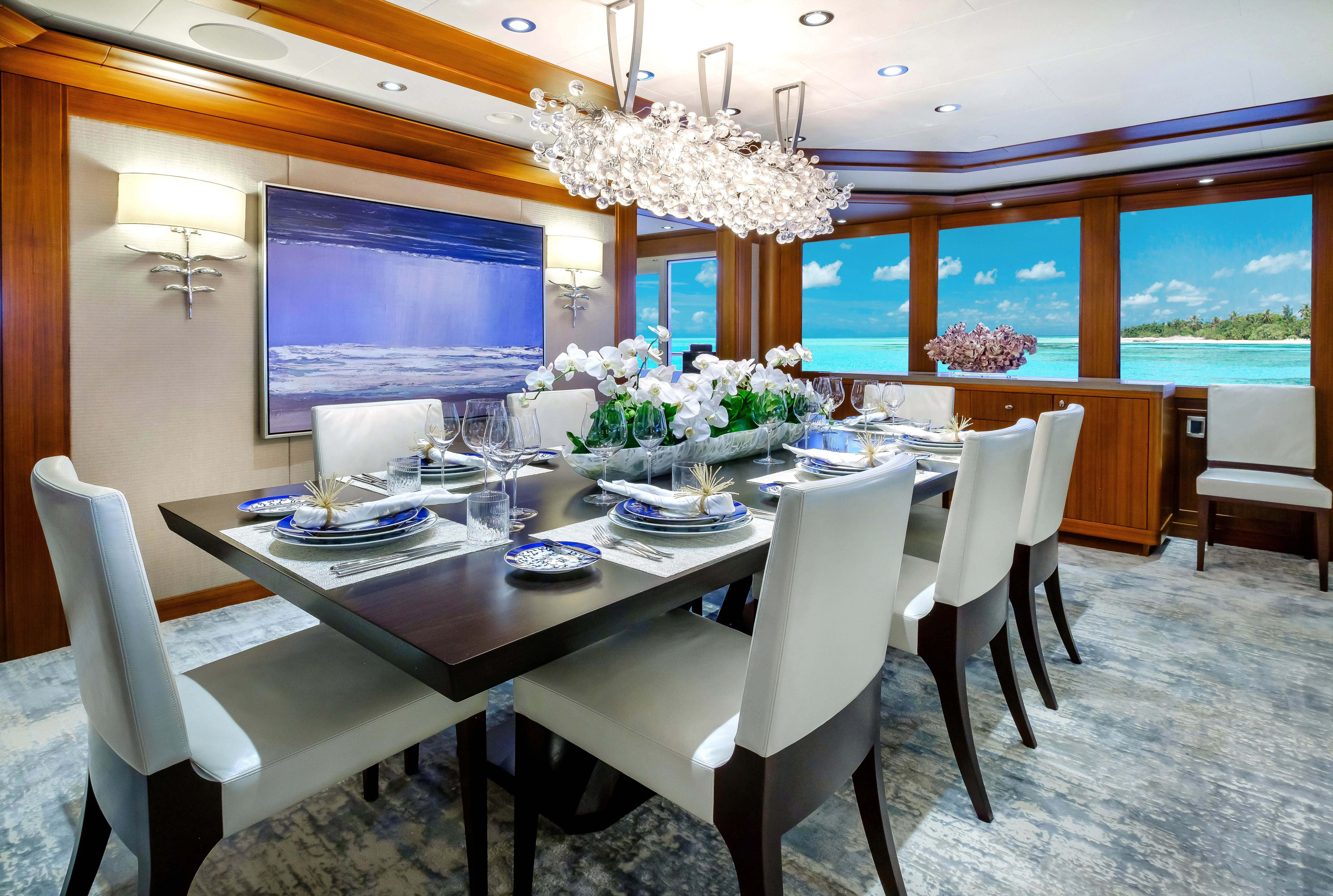 a large dining table with white chairs aboard MAISON BLANCHE Yacht for Charter