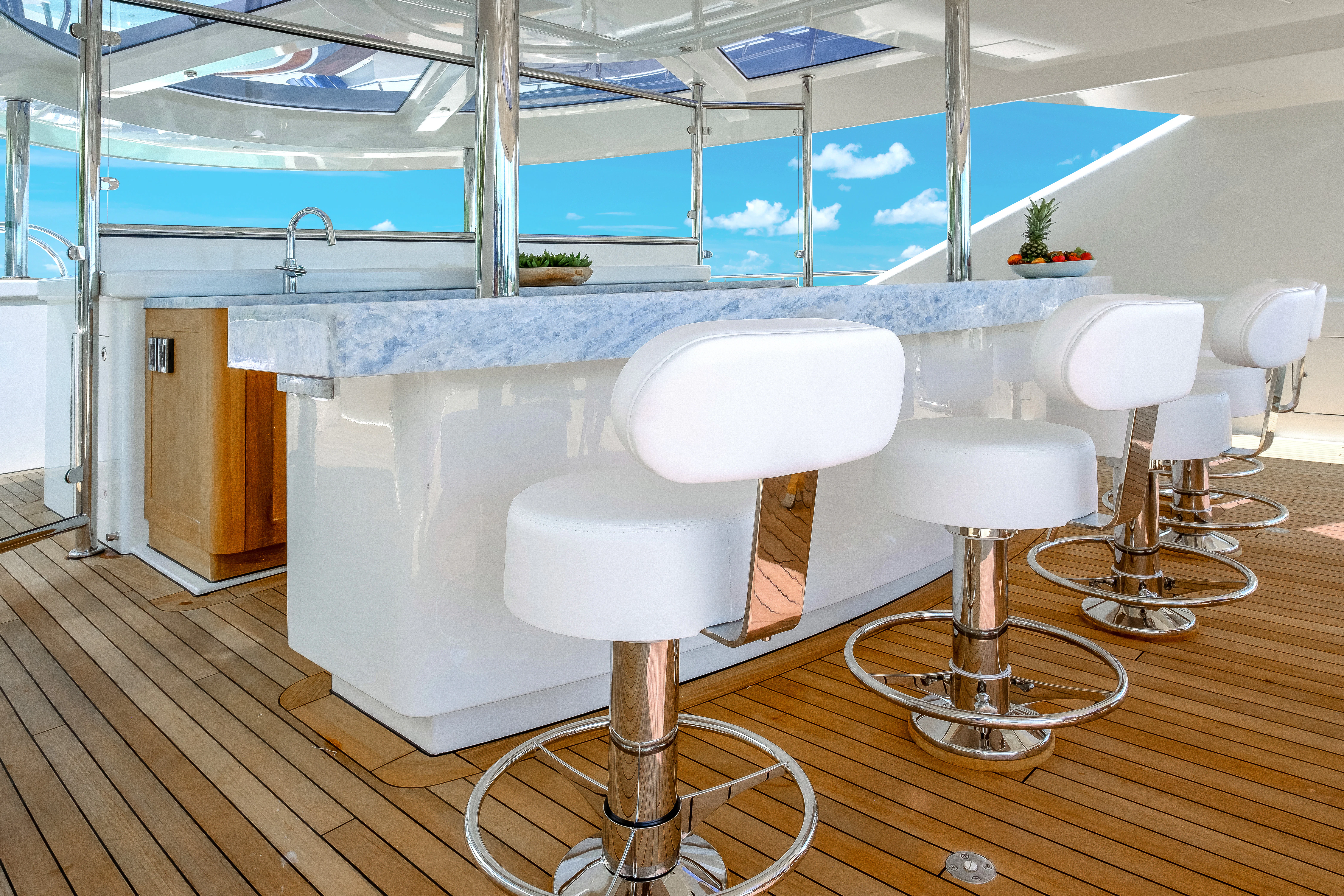a white kitchen with stools aboard MAISON BLANCHE Yacht for Charter
