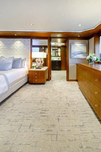 a bedroom with a bed and a dresser aboard MAISON BLANCHE Yacht for Charter