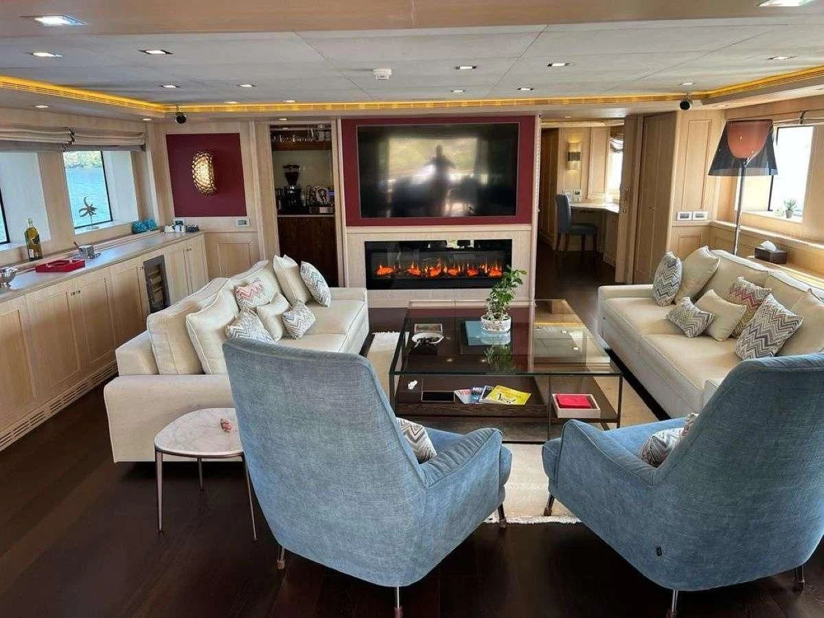a living room with a fireplace aboard PHOTON Yacht for Sale