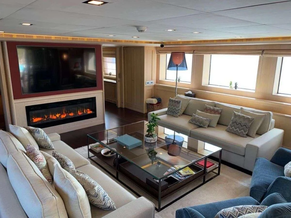 a living room with a fireplace aboard PHOTON Yacht for Sale