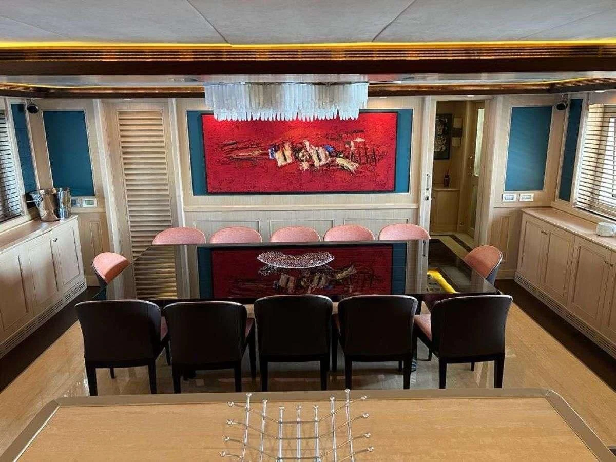 a room with tables and chairs aboard PHOTON Yacht for Sale