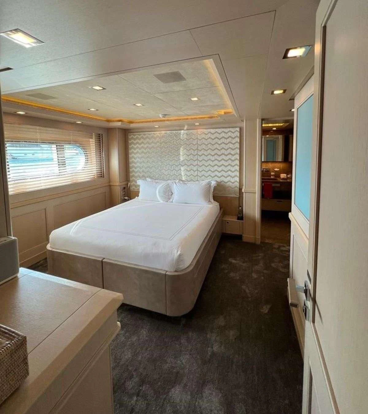 a bedroom with a bed and a table aboard PHOTON Yacht for Sale