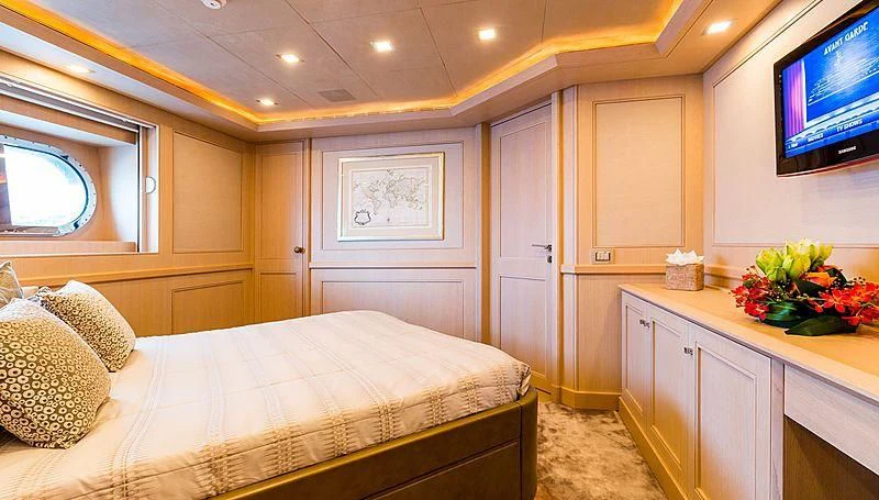 a bedroom with a bed and a tv aboard PHOTON Yacht for Sale