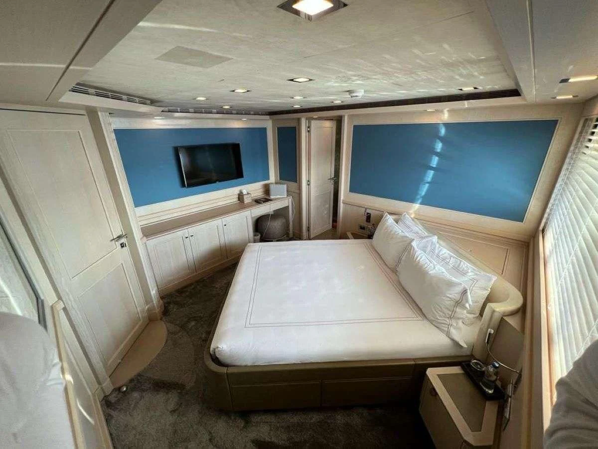 a room with a bed and a television aboard PHOTON Yacht for Sale