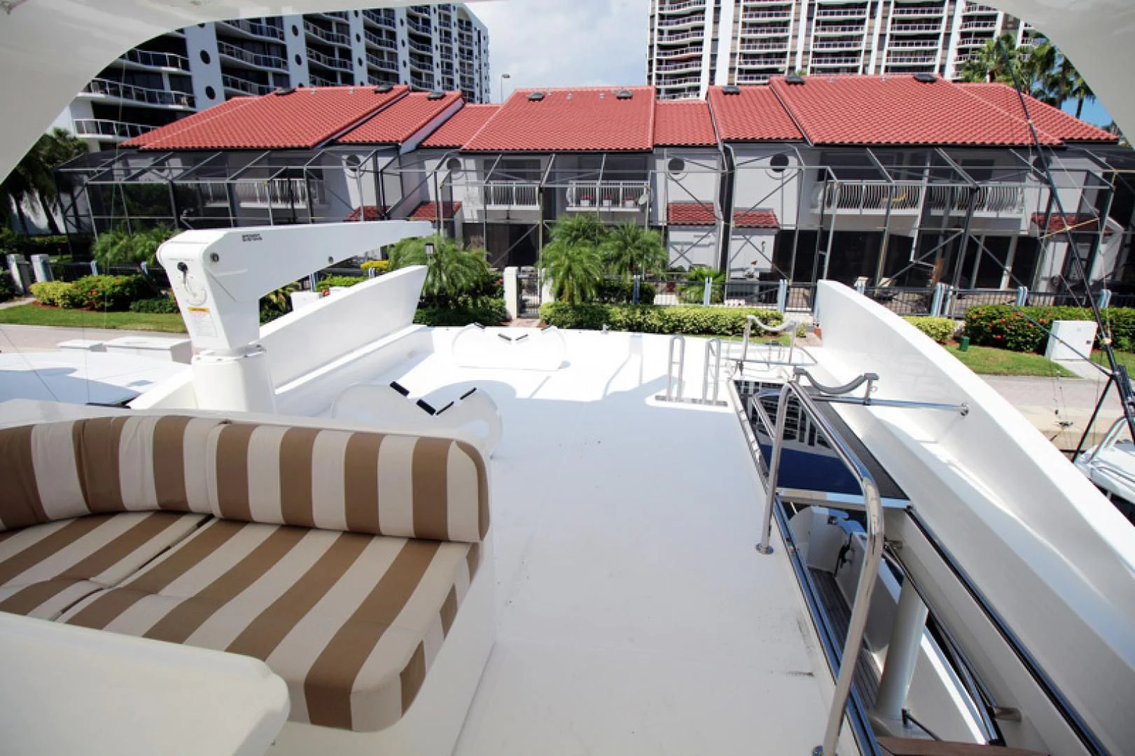 a lounge area with lounge chairs and a building in the background aboard ALWAYS SOMETHING Yacht for Sale