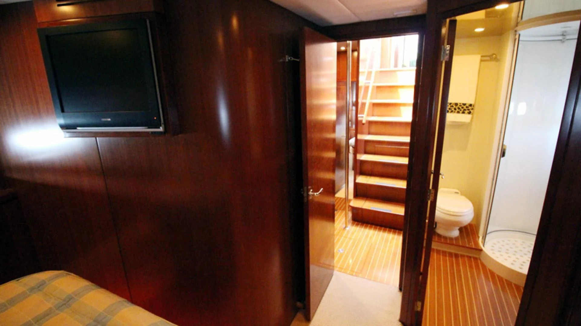 a room with a wood door and a tv on the wall aboard ALWAYS SOMETHING Yacht for Sale