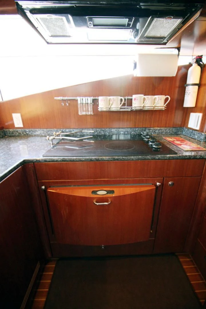 a kitchen with a sink and a shelf with a book aboard ALWAYS SOMETHING Yacht for Sale