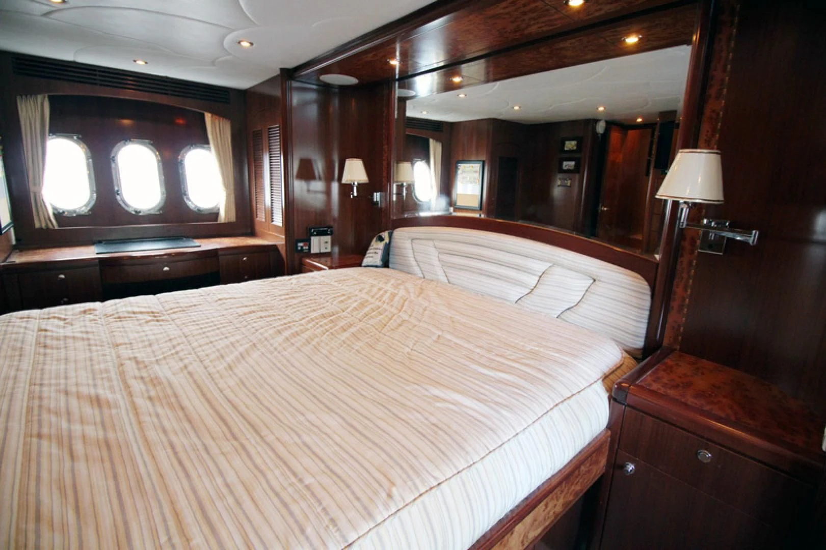 a bedroom with a bed and a mirror aboard ALWAYS SOMETHING Yacht for Sale