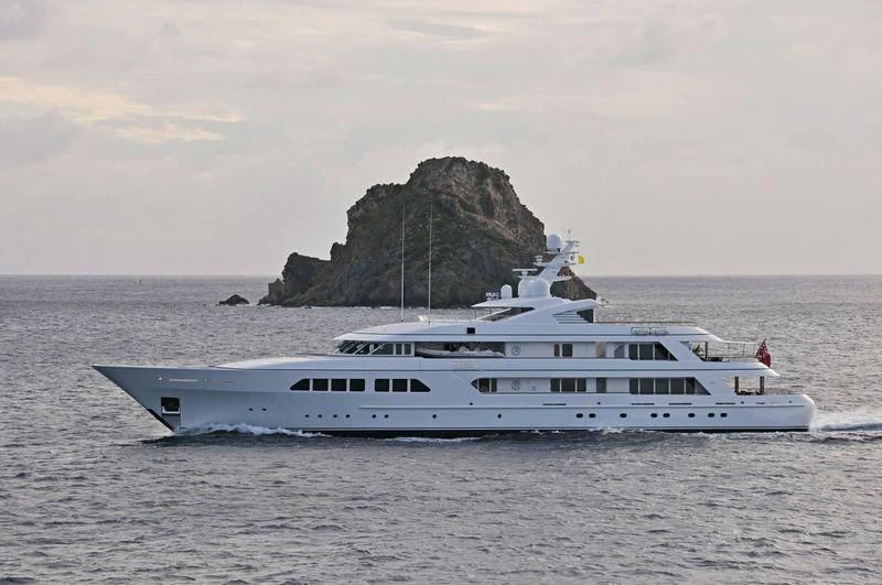 a boat on the water with Haystack Rock in the background aboard MAJESTIC Yacht for Sale