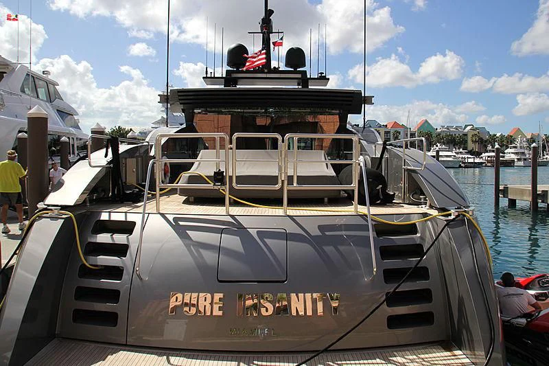 a boat with a flag on the front aboard PURE INSANITY Yacht for Sale