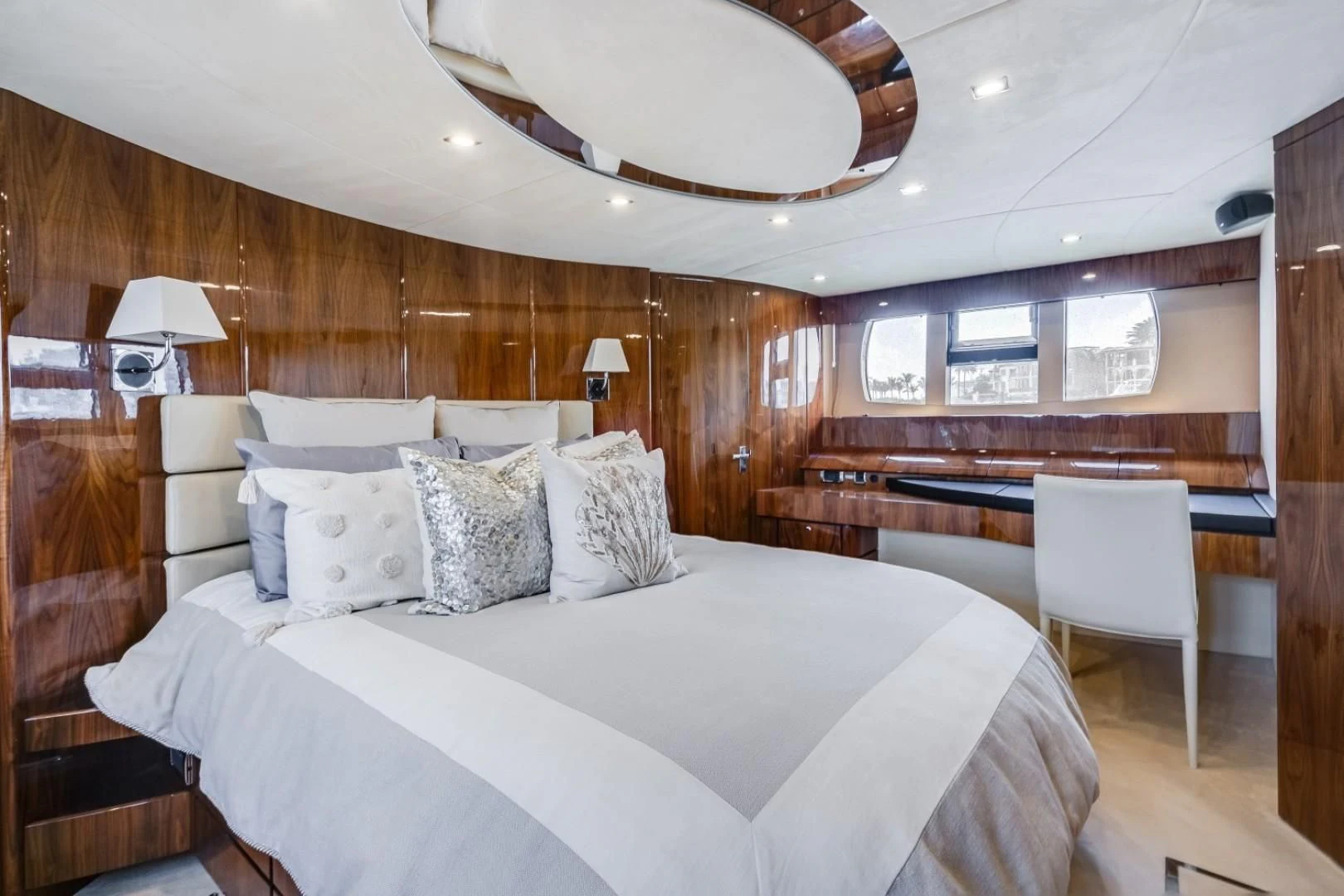 a bed with a white sheet and pillows in a room with a wood wall and a window with aboard DIRECT TO Yacht for Sale