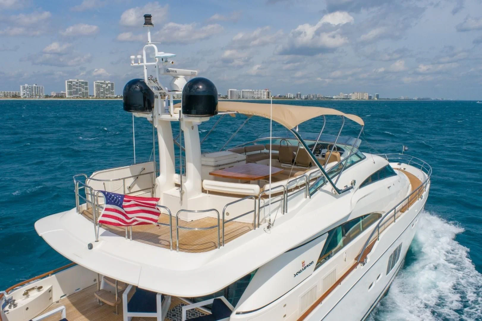 a boat with a flag on the front aboard DIRECT TO Yacht for Sale