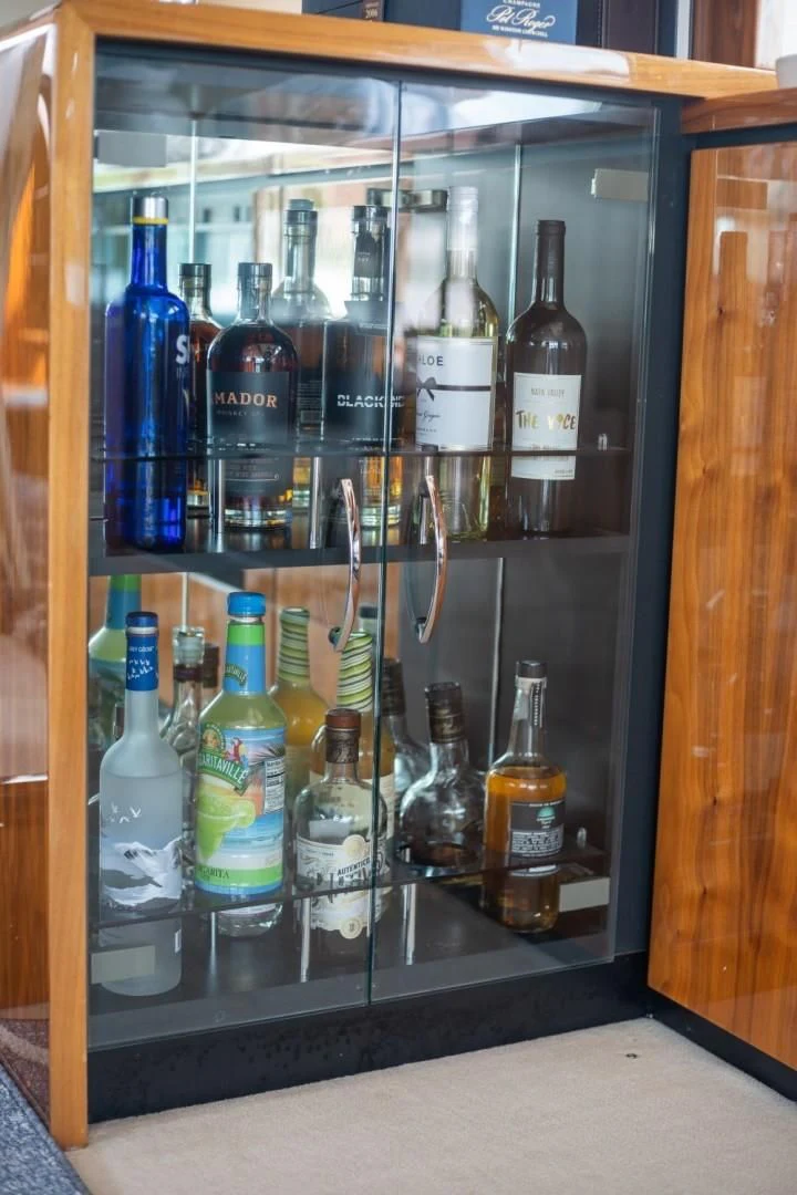 a cabinet with bottles and glasses aboard DIRECT TO Yacht for Sale