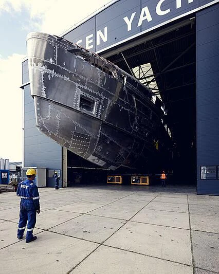 a person in a hard hat standing in front of a large ship aboard ULTRA G Yacht for Sale