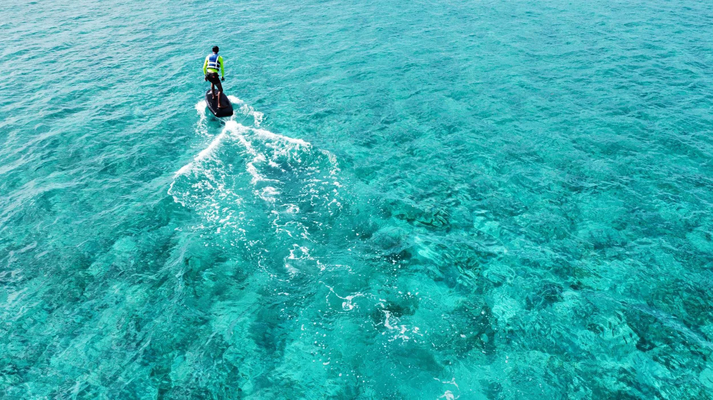 a man riding a wave aboard PRINCESS MILA Yacht for Charter
