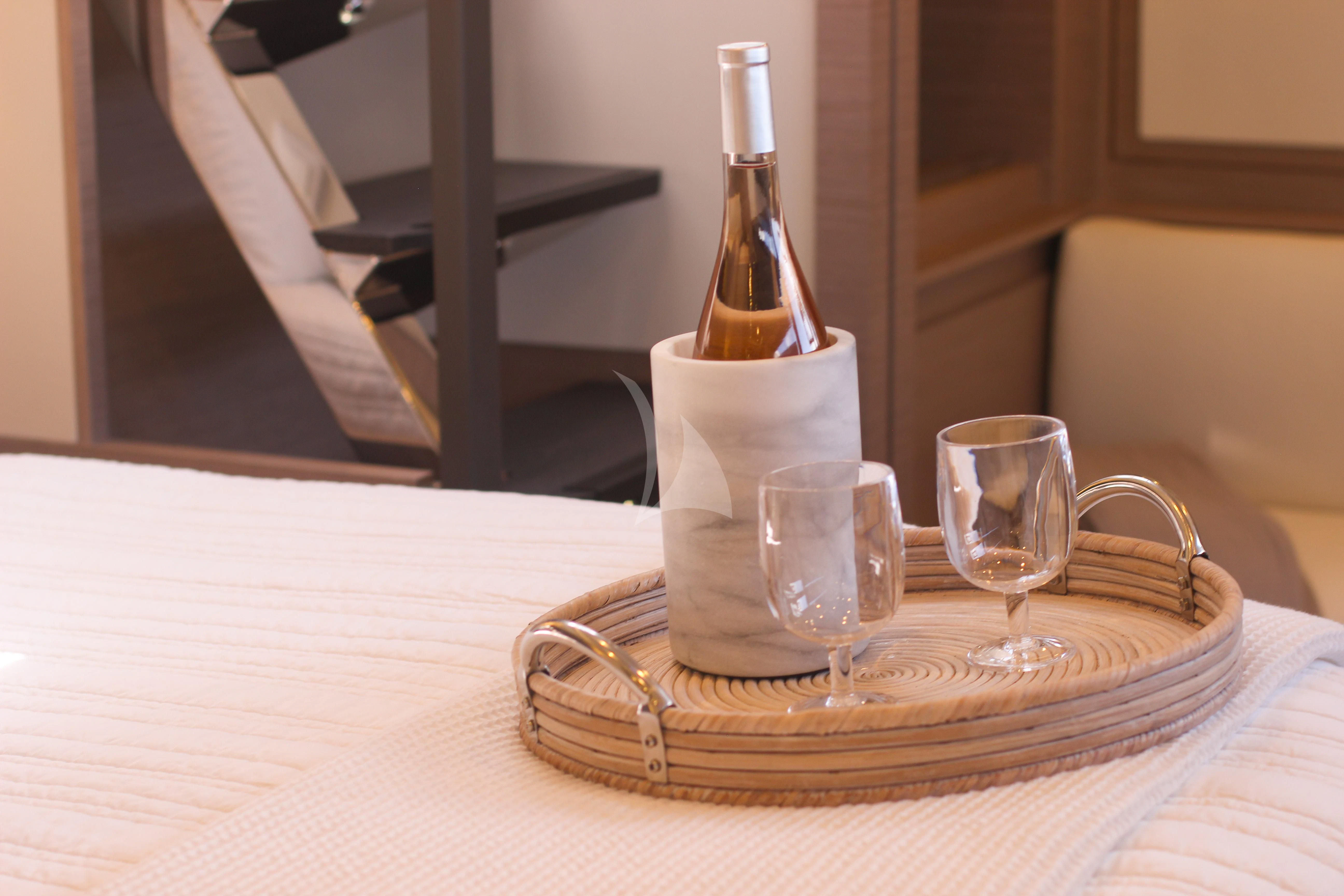 a bottle of wine and glasses on a table aboard PRINCESS MILA Yacht for Charter