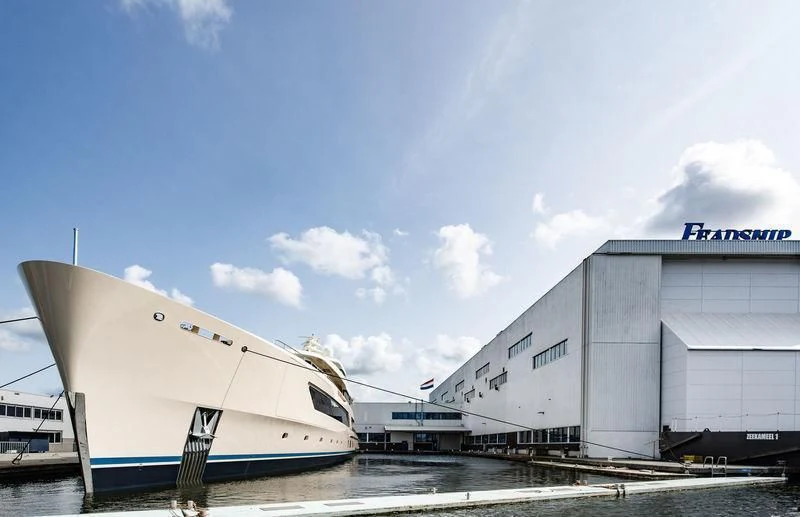 a large white boat sits next to a building aboard SAMAYA Yacht for Sale