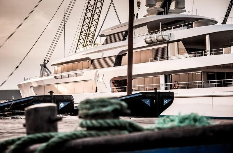 a large white boat with a black car parked in front of it aboard SAMAYA Yacht for Sale