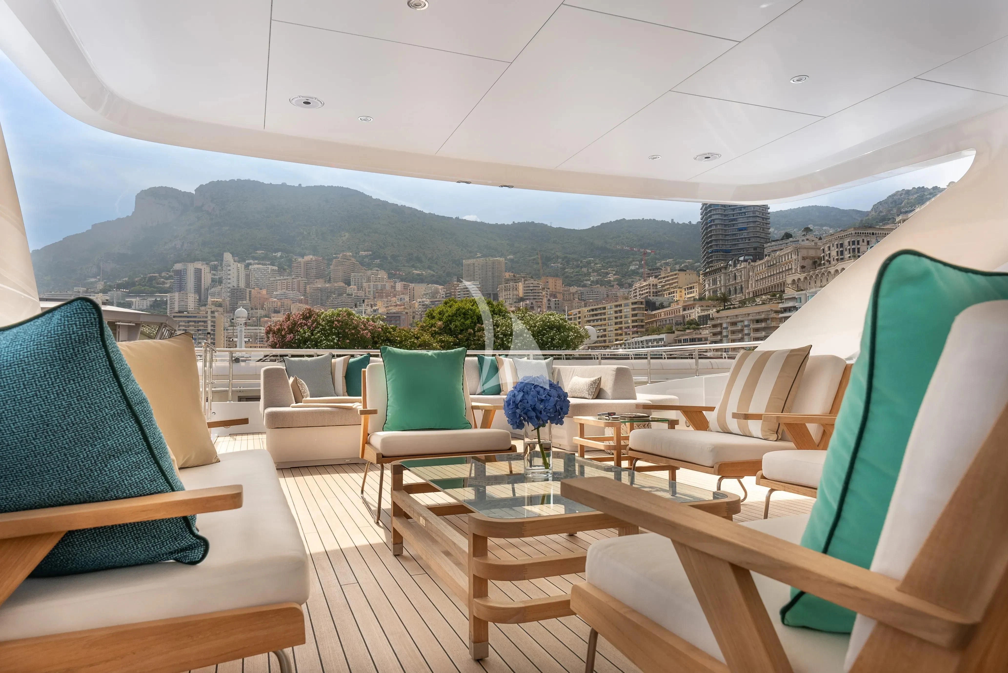 a deck with chairs and a city in the background aboard RELIANCE Yacht for Sale