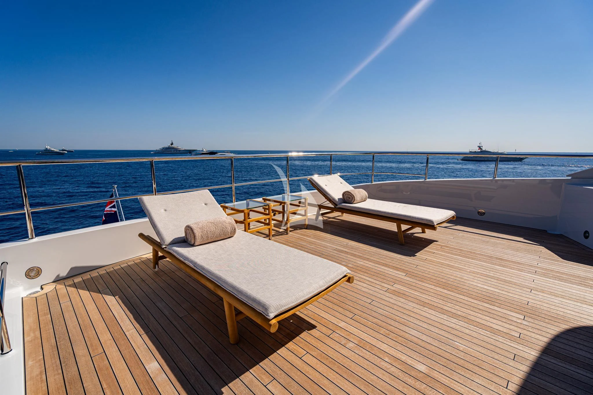 a deck with chairs and a body of water in the background aboard RELIANCE Yacht for Sale