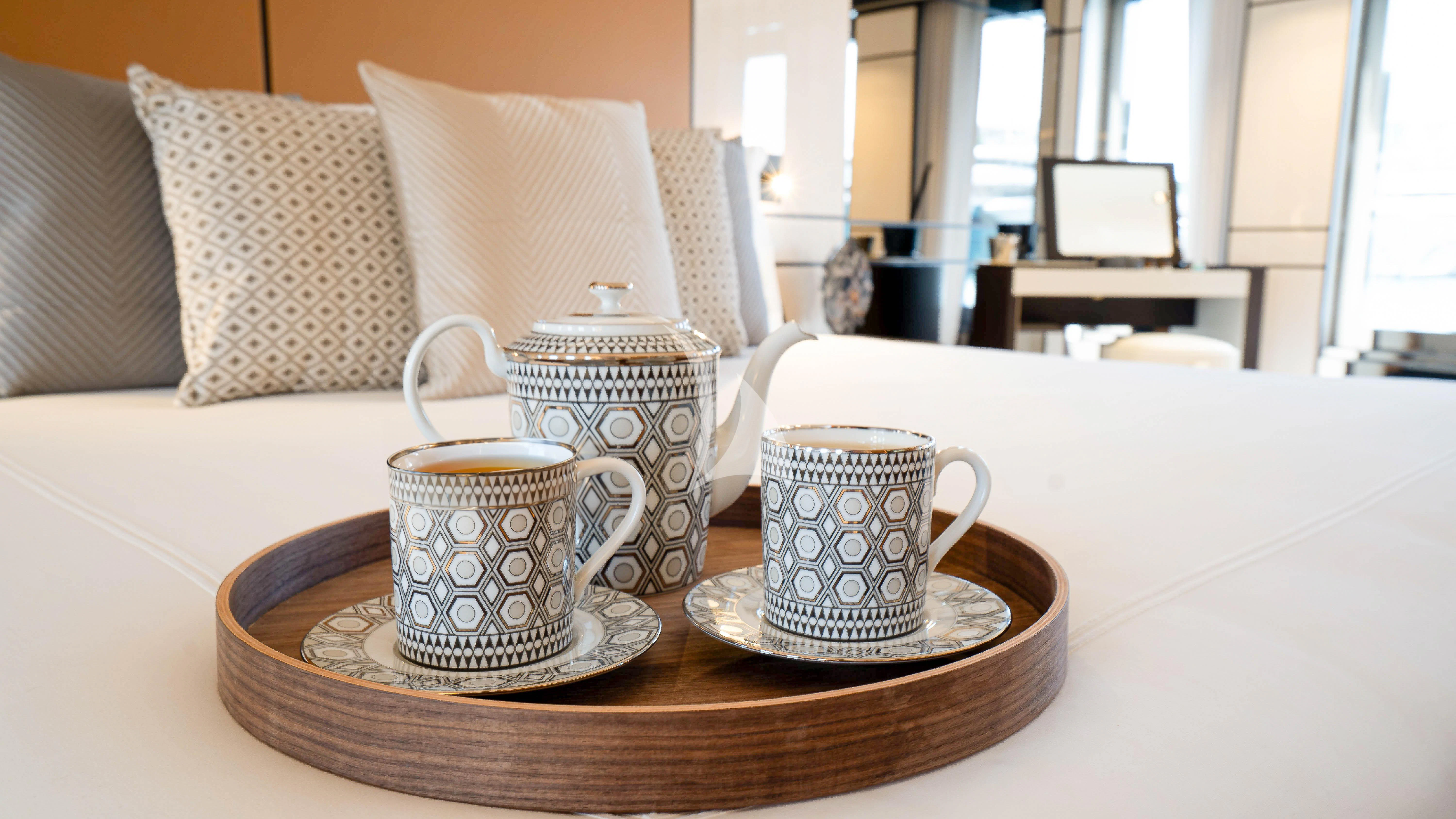 a coffee table with a tray of coffee cups and a book on it aboard RELIANCE Yacht for Sale