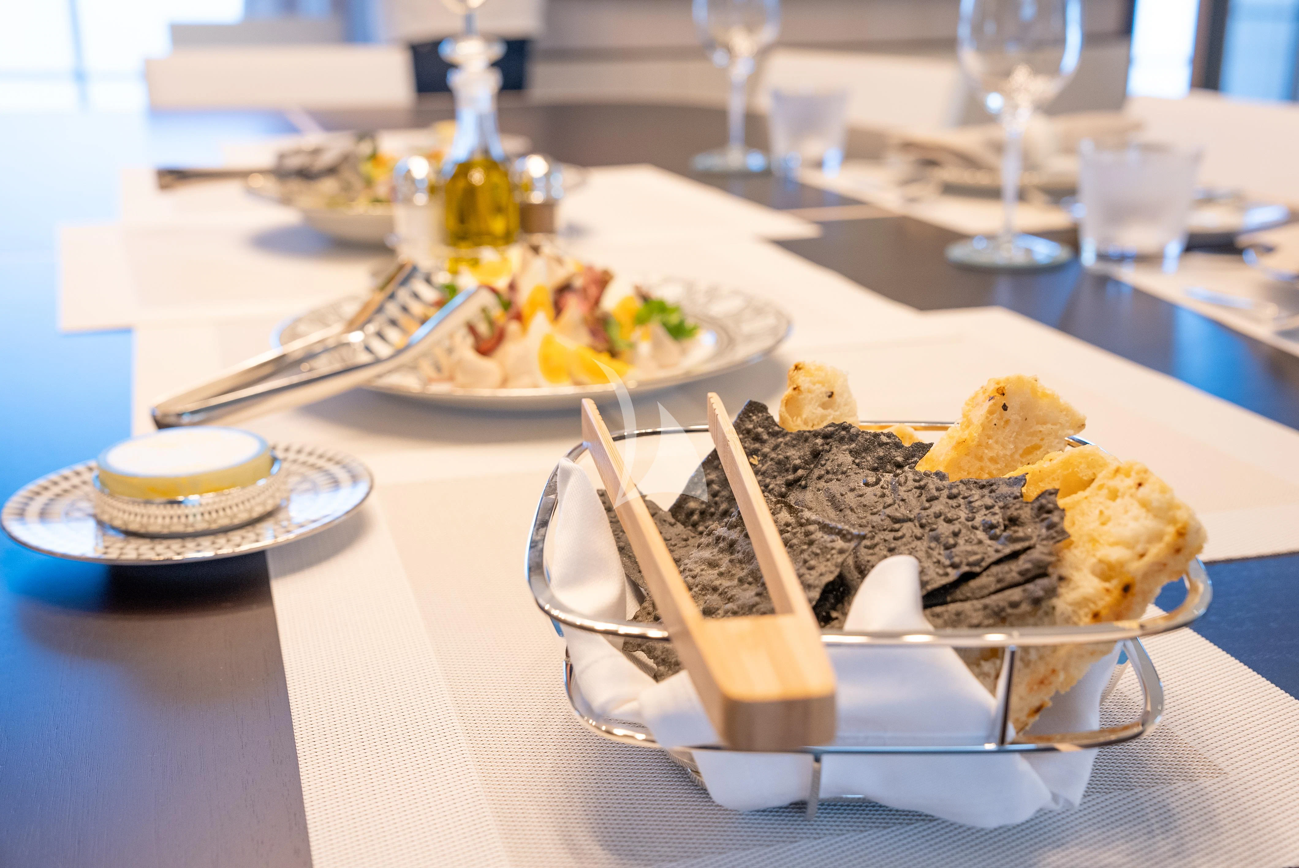 a table with plates of food and glasses on it aboard RELIANCE Yacht for Sale