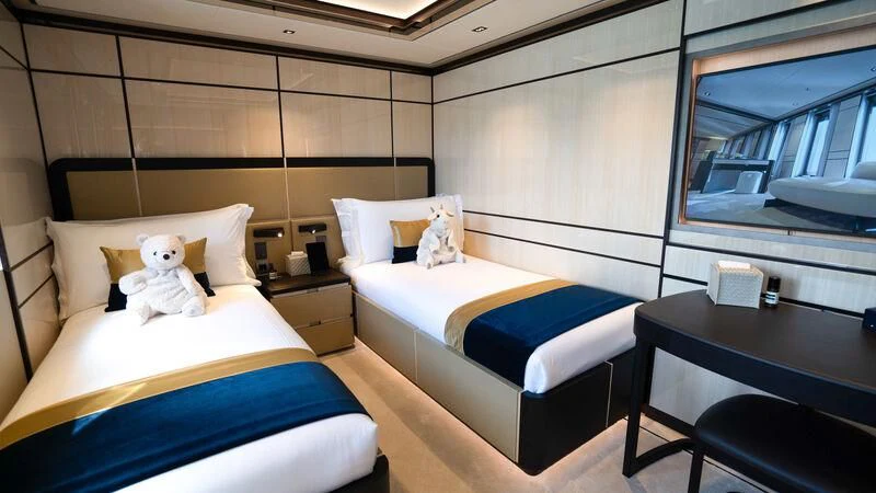 a room with beds and a table aboard RELIANCE Yacht for Sale