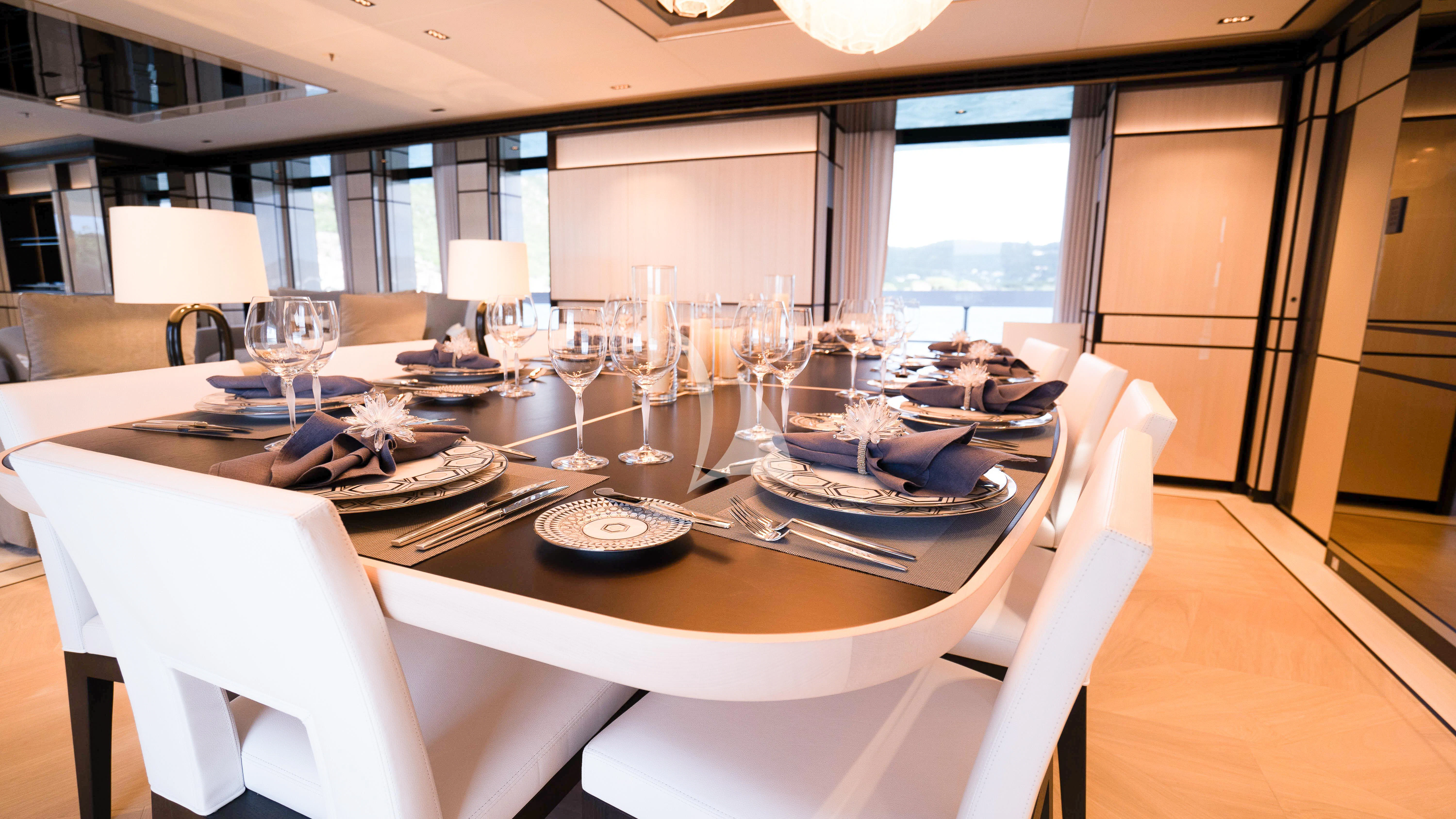 a table set with plates and glasses aboard RELIANCE Yacht for Sale