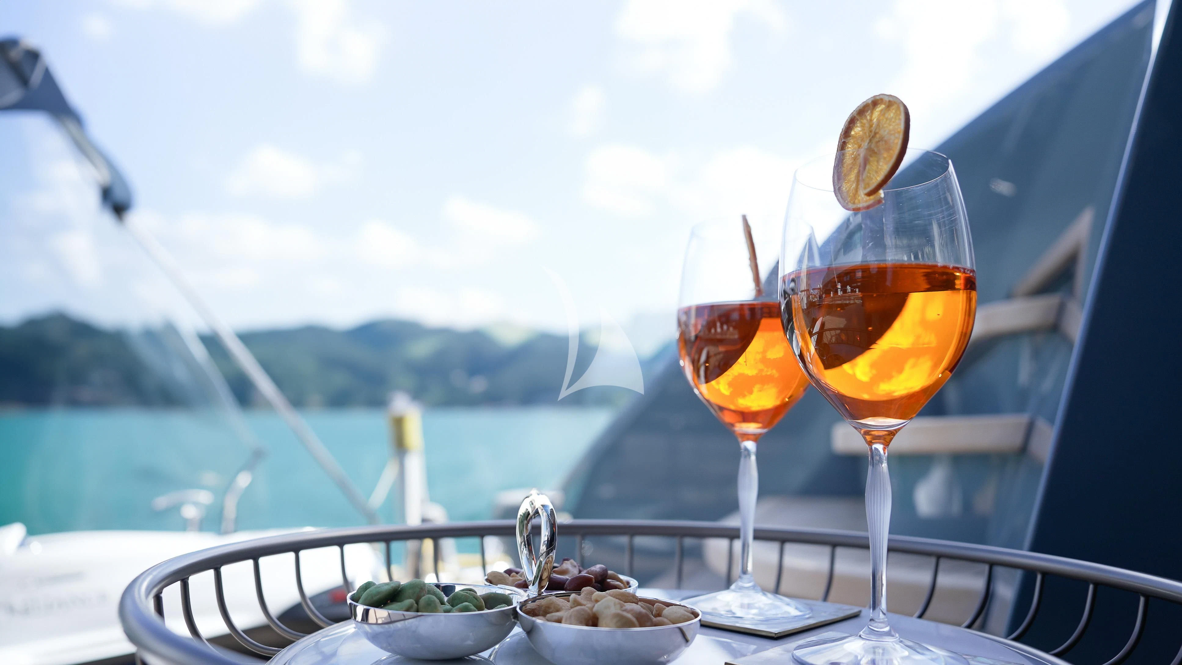 a glass of wine and a bowl of food on a table aboard RELIANCE Yacht for Sale