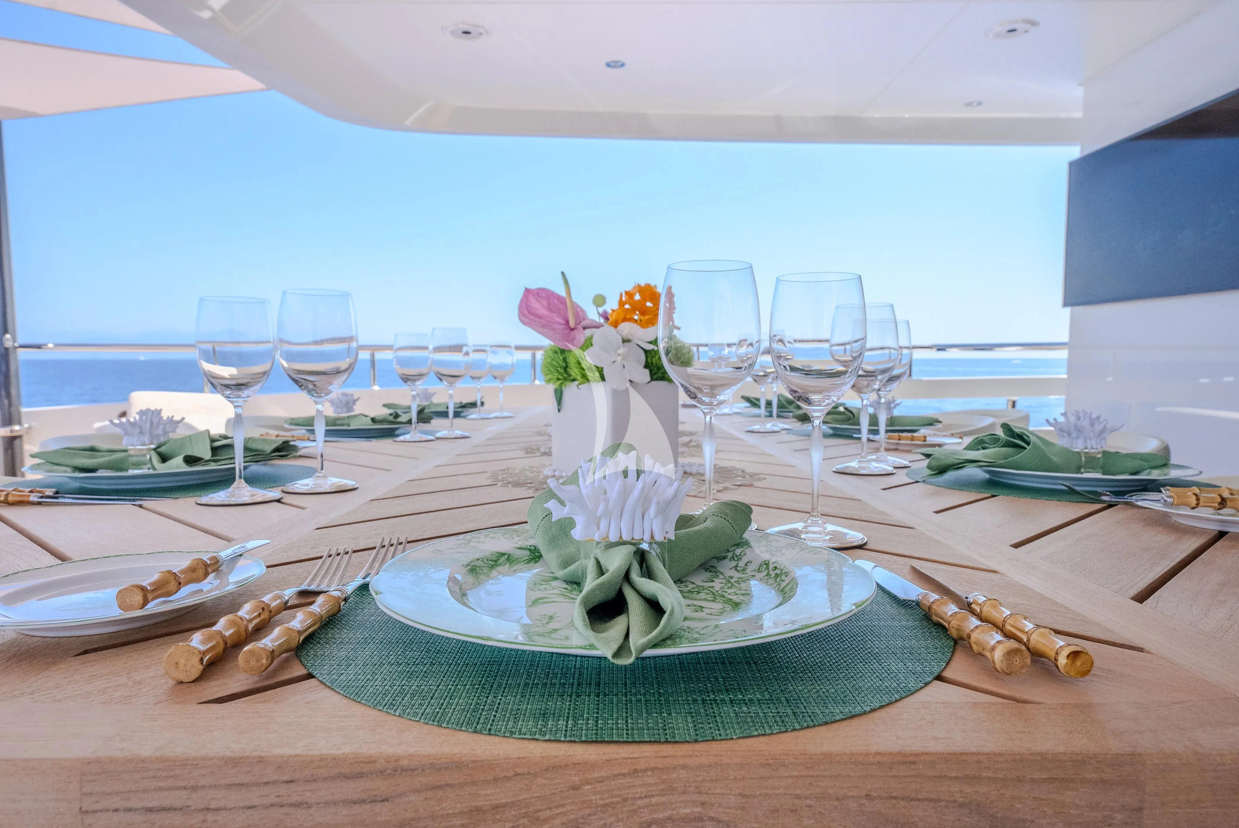 a table with plates and glasses aboard RELIANCE Yacht for Sale