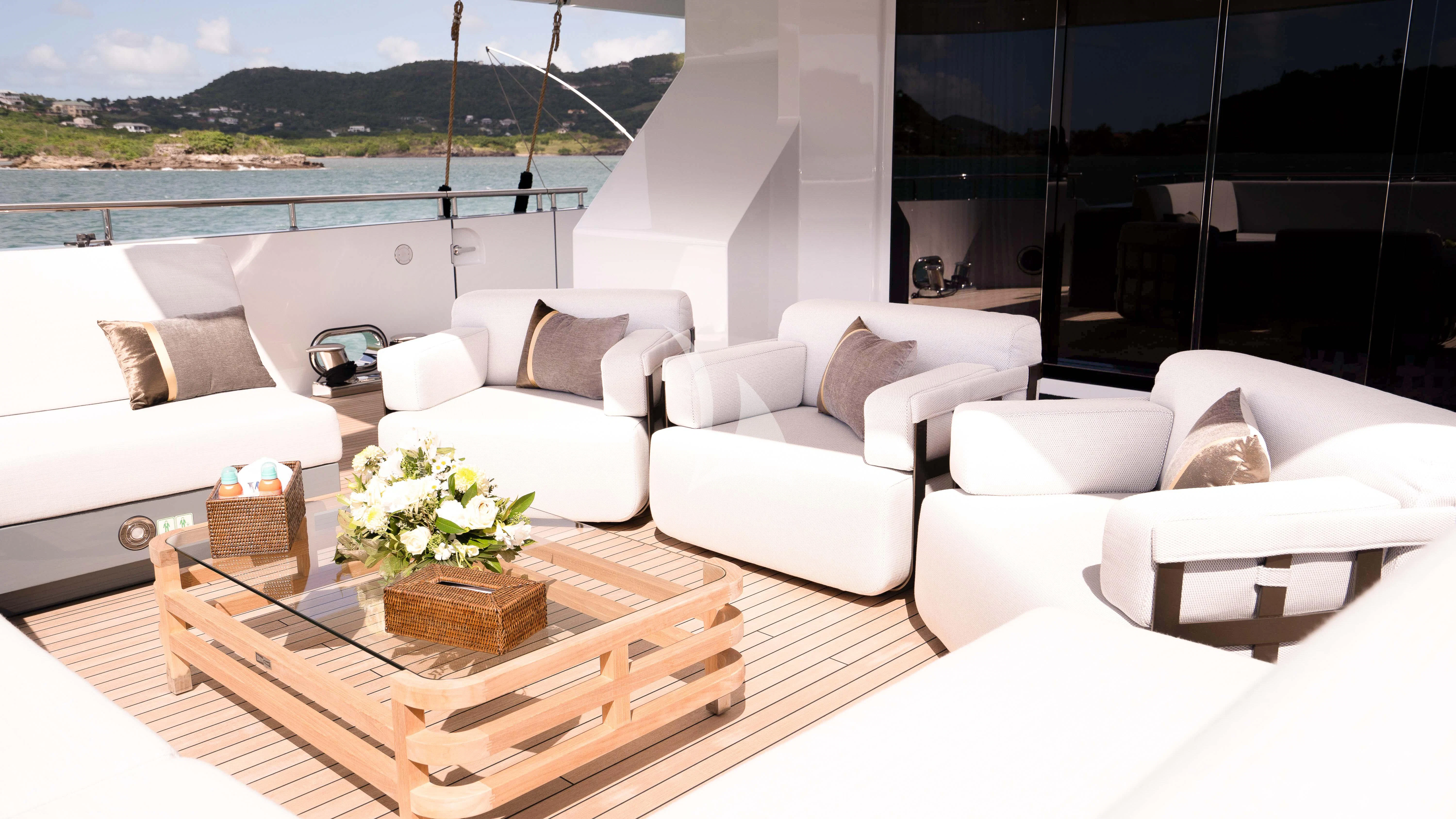 a living room with white couches and a table aboard RELIANCE Yacht for Sale