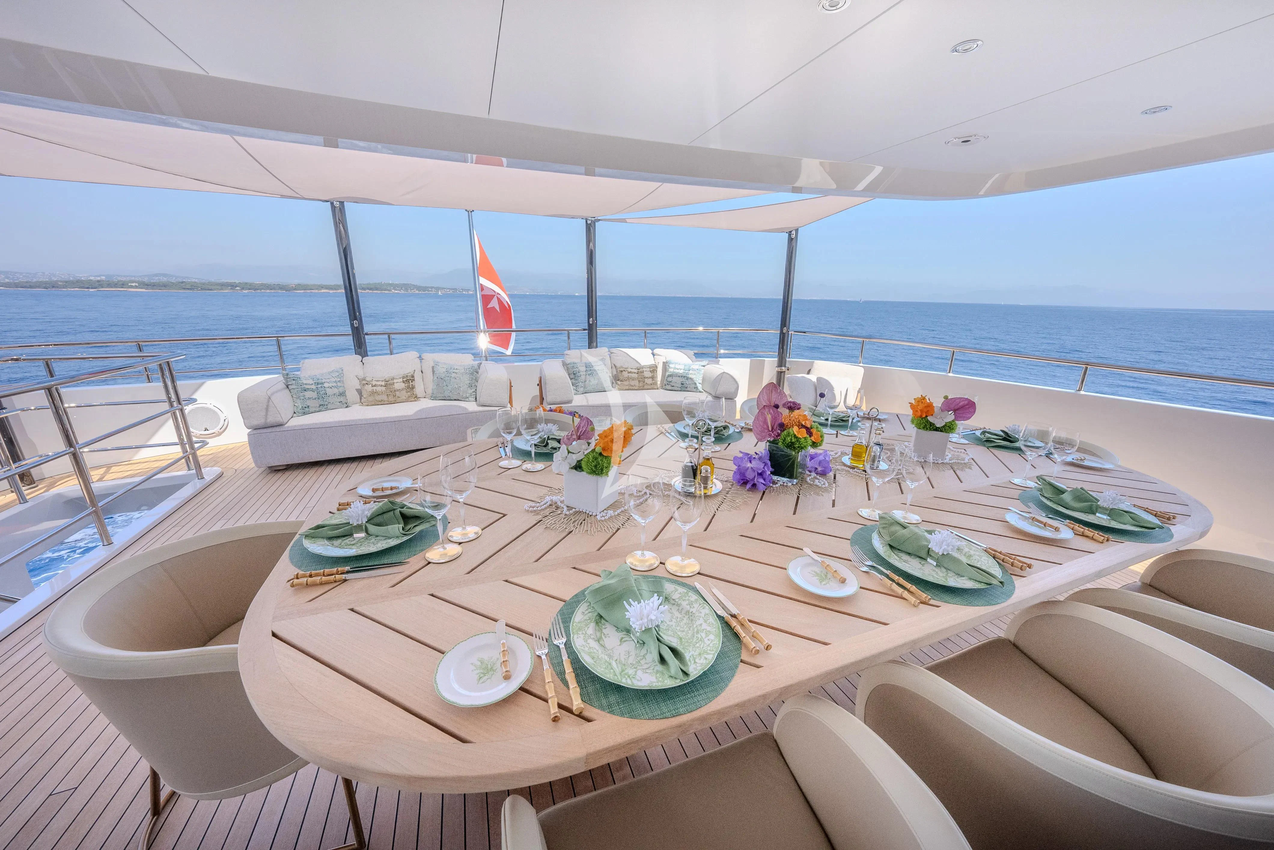 a table with plates and flowers on it aboard RELIANCE Yacht for Sale
