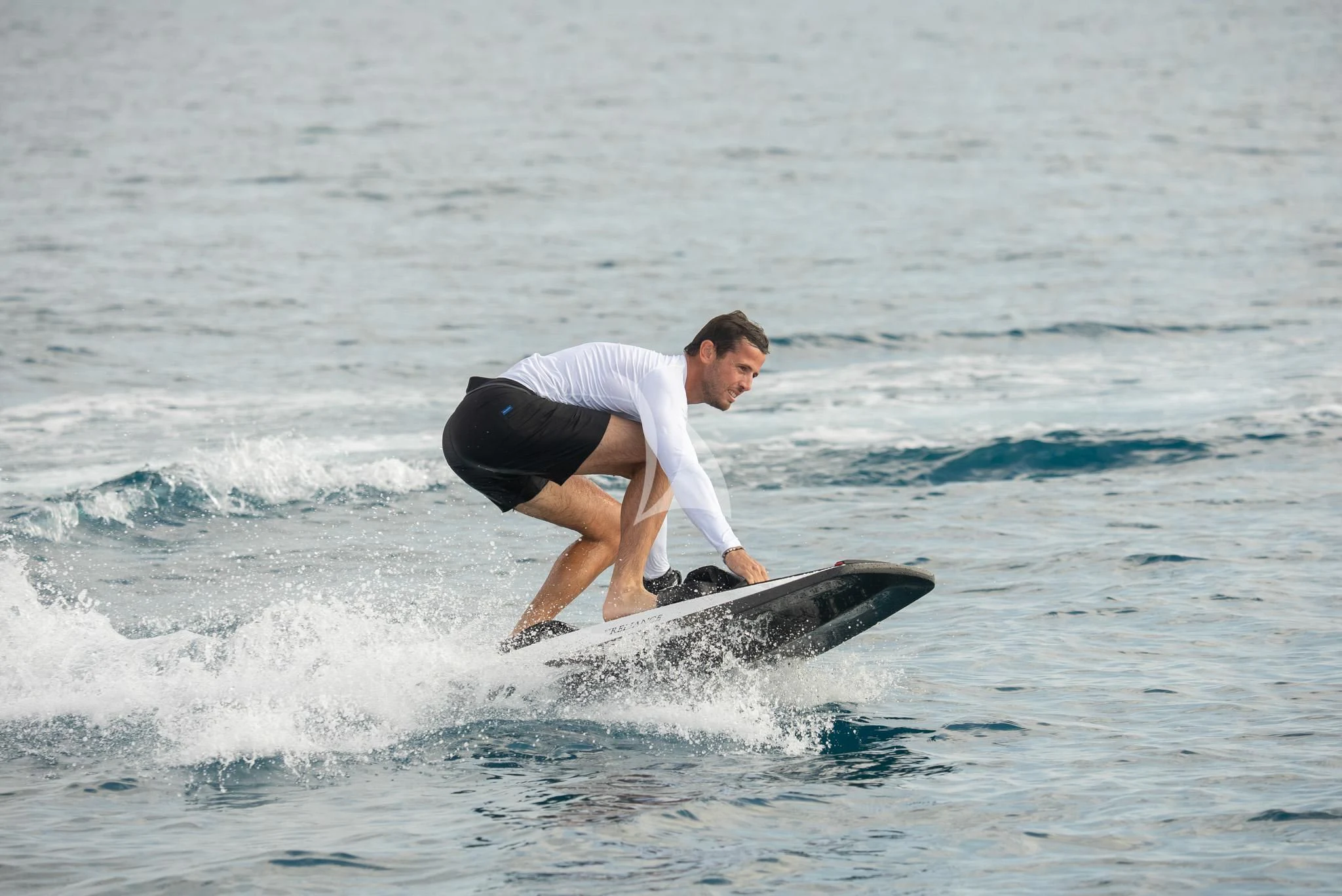 a man surfing on the waves aboard RELIANCE Yacht for Sale
