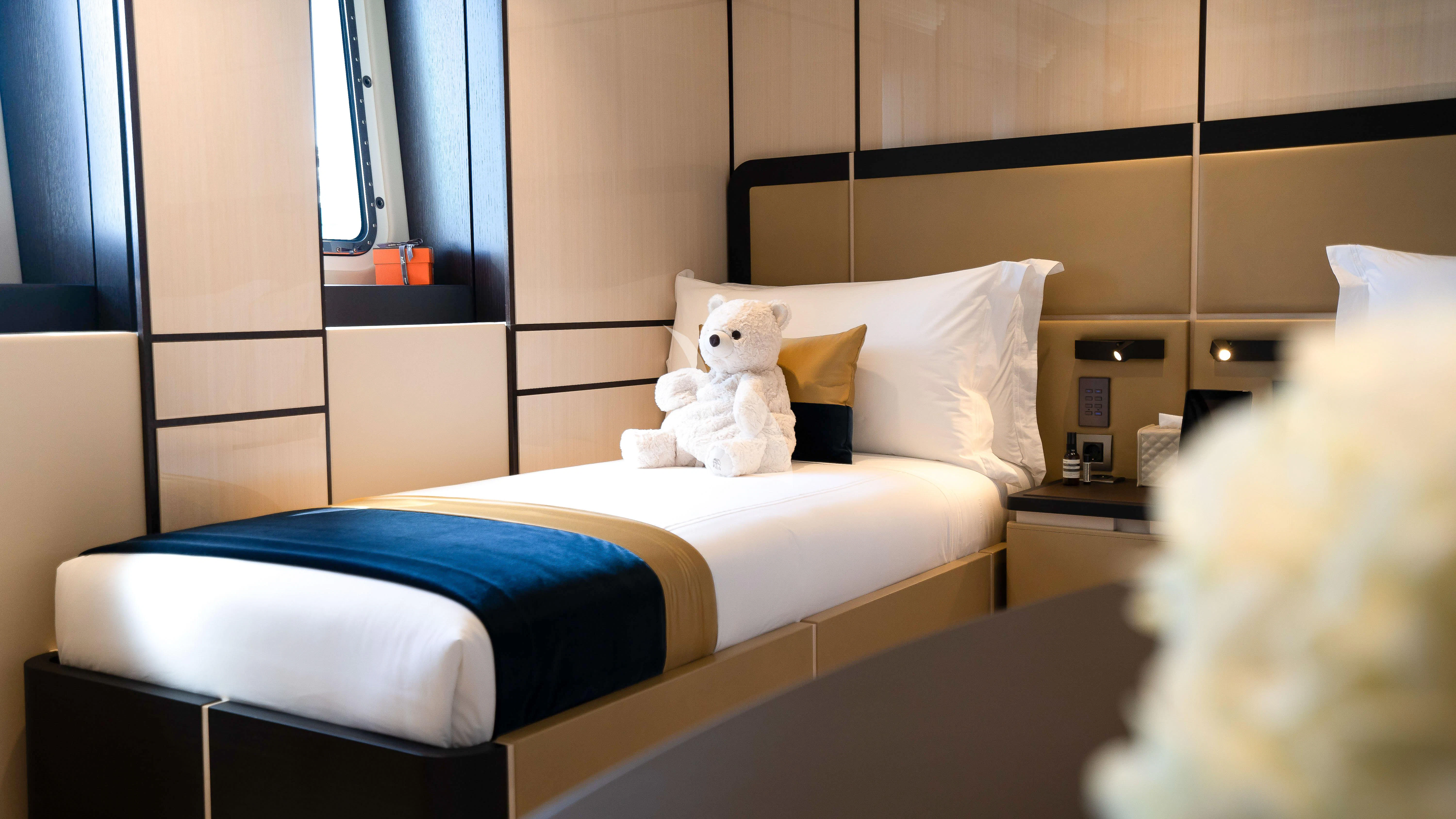 a teddy bear on a bed aboard RELIANCE Yacht for Sale