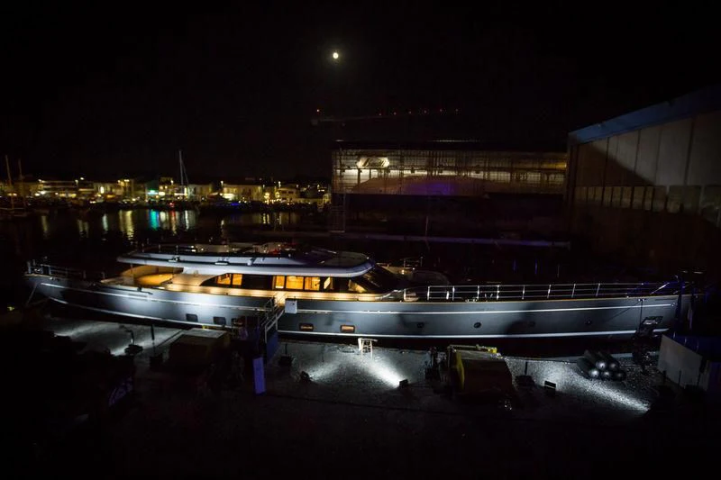 a large building with a bridge over it at night aboard SEVEN Yacht for Sale