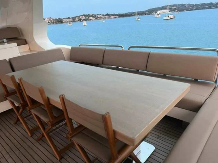 a table with chairs on it by a body of water aboard VIVERE Yacht for Sale
