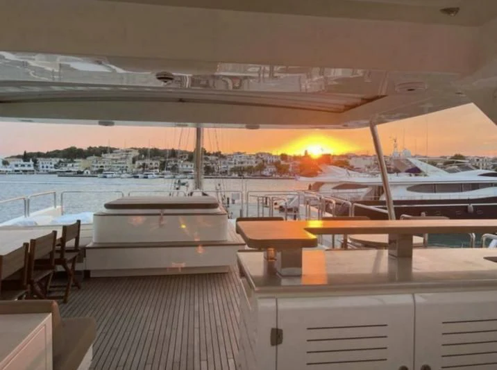 a large room with a view of the water and the sun setting aboard VIVERE Yacht for Sale
