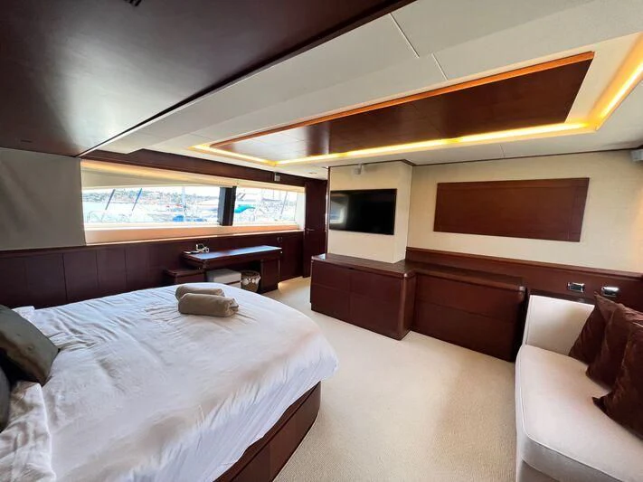a room with a bed and a television aboard VIVERE Yacht for Sale